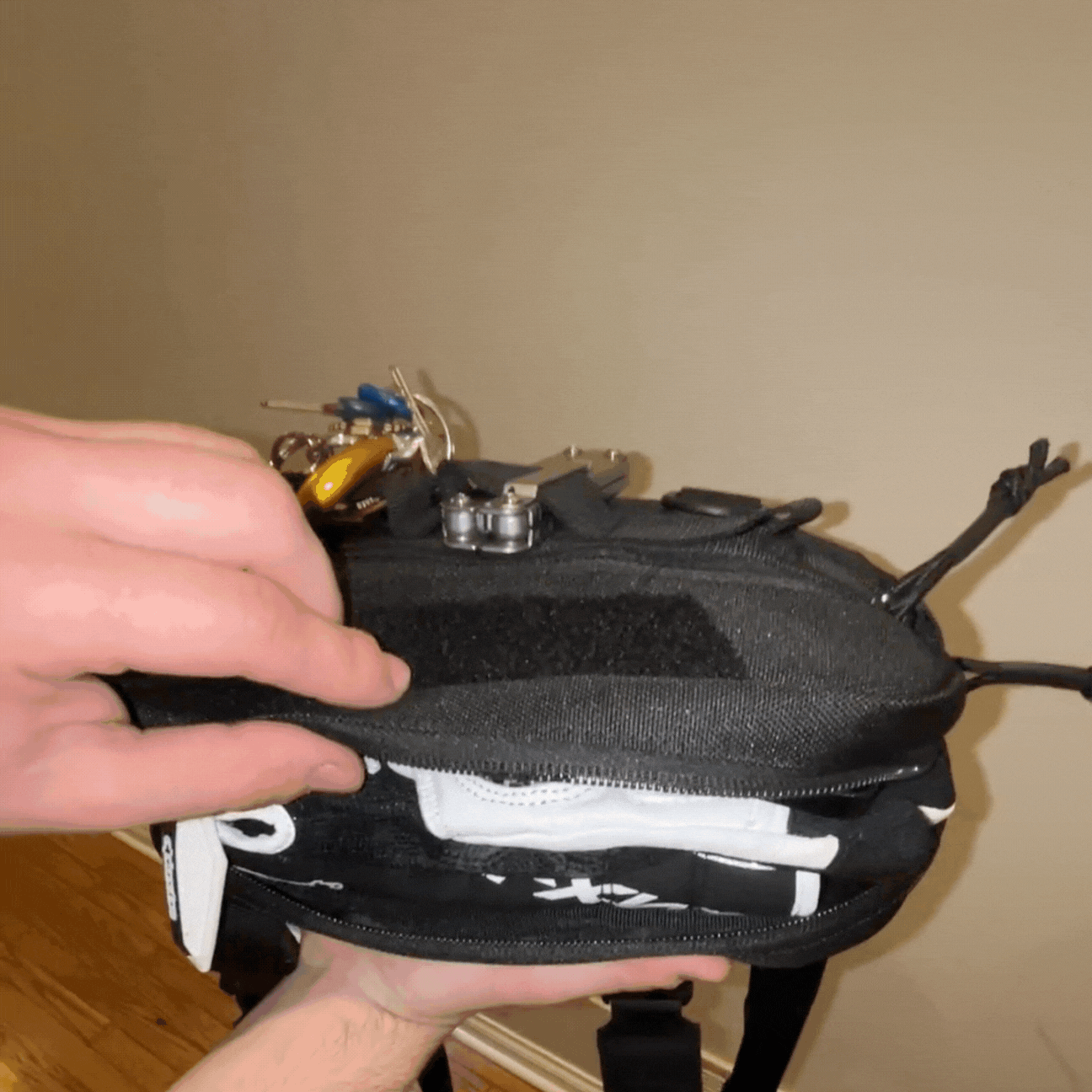 GIF showing tactical chest bag being opened to reveal keys, tools, and gear, highlighting its storage capacity and organization.